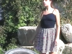 Coward young lady pees on an outdoor walk