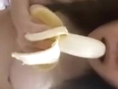 Asian playing with a banana before jamming it in her pussy